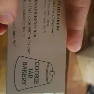 a hand holding a business card