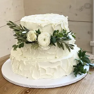 a white wedding cake with fresh flowers