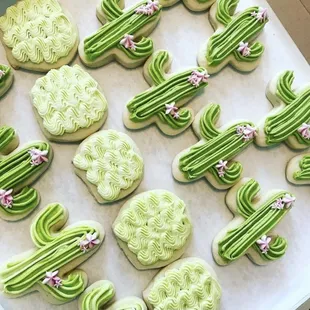 a tray of decorated cactus cookies