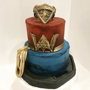 a three tiered cake decorated like wonder wonder woman
