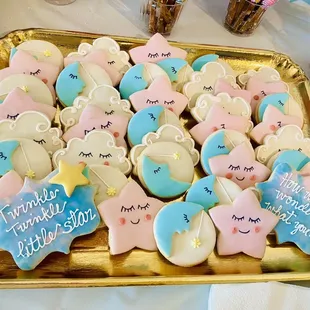 a tray of decorated cookies for a baby shower