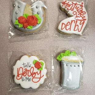 four decorated cookies in plastic bags