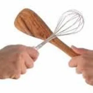 two hands holding a whisk