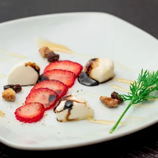 Thin sliced California strawberry, with mozzarella drizzled with a balsamic reduction, toasted walnuts, dried raisins, cracked black pepper