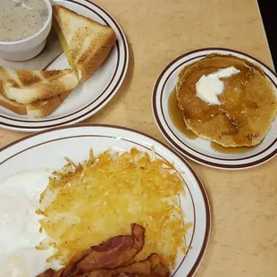 a breakfast of eggs, hash browns, bacon and pancakes