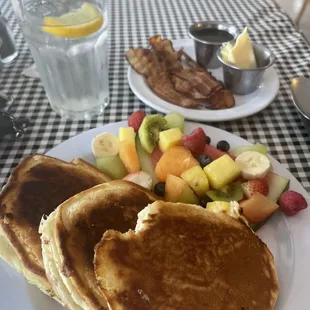 Pancakes with fresh fruit and a side of bacon