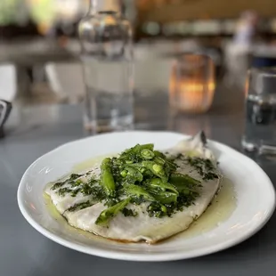 a plate of fish with broccoli on it