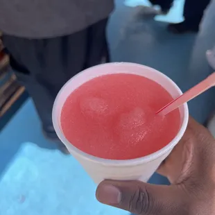 a hand holding a cup of watermelon