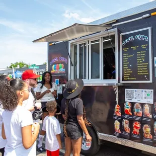 a group of people standing in front of a food truck