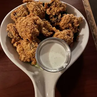 a plate of fried chicken with a side of ranch dressing