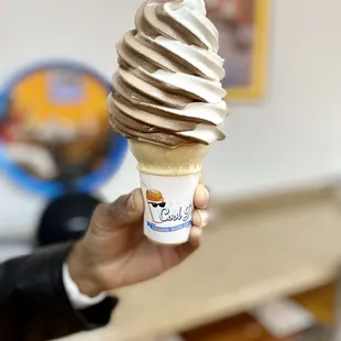 a hand holding a soft ice cream cone