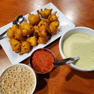 a plate of fried food and a bowl of sauce