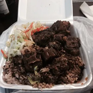 Large oxtail with beans and rice and a salad.