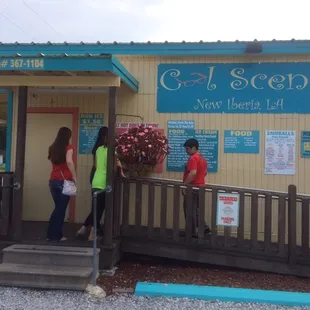 a woman and two children entering a store