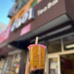 a hand holding a cup of bubble tea