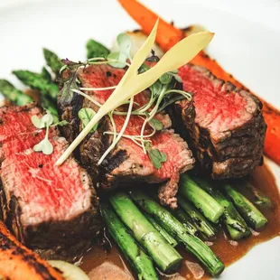 Chargrilled Fillet Mignon, with marinated grilled asparagus, roasted baby carrots, sous-vide cippolini onions, and roasted garlic.