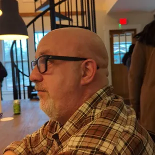 a man sitting at a table with a glass of wine