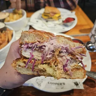 a hand holding a sandwich