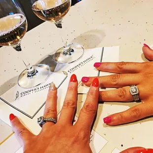  a woman's hand with red nails and a wine glass