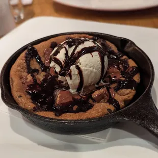  a skillet with ice cream and chocolate sauce