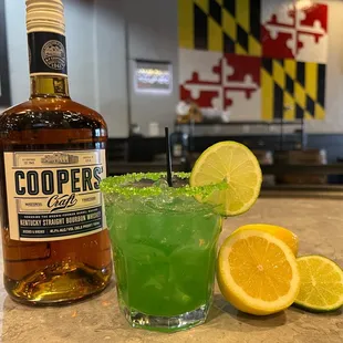 a glass of limeade and a bottle of gin
