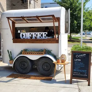 a coffee trailer with a sign on the side of it