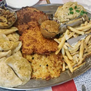 Mix of pierogi's to share, potato pancakes, kielbasa sandwich, fried onions and applesauce in the small bowls.