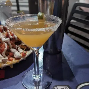 a cocktail and a plate of nachos