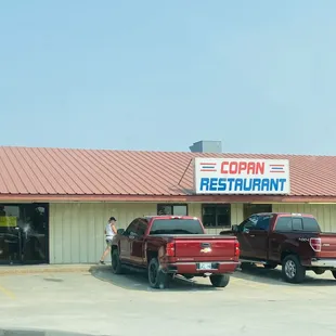two trucks parked in front of a restaurant