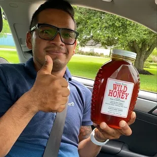 a man holding a jar of honey