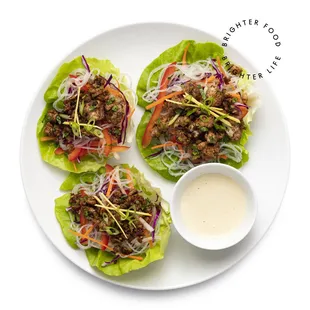 a plate of lettuce wraps with meat and vegetables