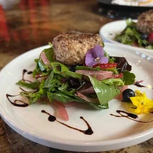 Pecan crusted goat cheese on greens with edible flowers