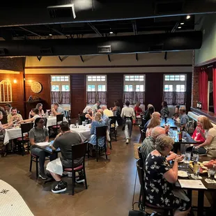 a large group of people sitting at tables in a restaurant