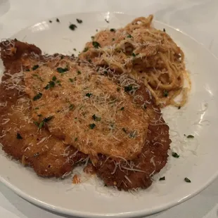 Romano-crusted chicken with a side of spaghetti and tomato cream sauce