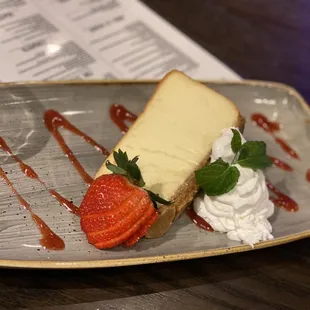 a piece of cheesecake with strawberries and whipped cream