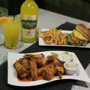 two plates of food and a bottle of beer