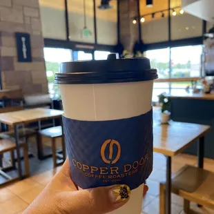 a hand holding a coffee cup