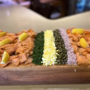 smoked salmon, capers, and capers on a wooden board