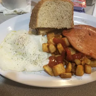 Over easy eggs, bologna, home fries and rye toast