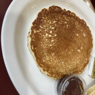 a plate of pancakes with butter and syrup