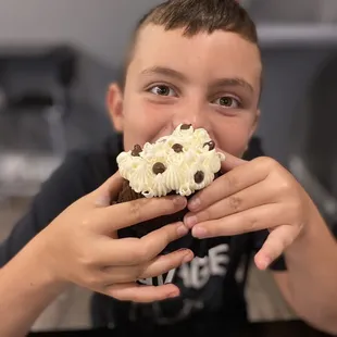 a boy eating a cupcake