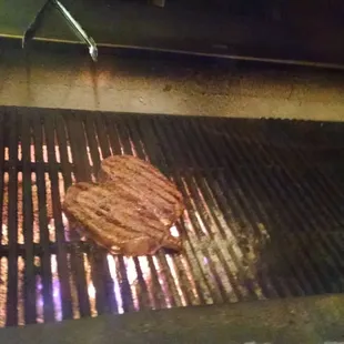 Our two bone in ribeyes on the grill. They cook them right in front of you over a wood fire. Smells so good!