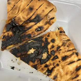 two slices of pizza in a styrofoam container