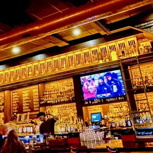 people at a bar watching tvs