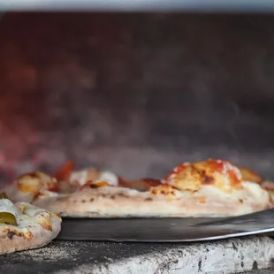 two pizzas cooking in an oven