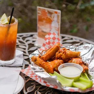 a plate of chicken wings and a drink