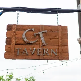 a wooden sign hanging from the side of a building