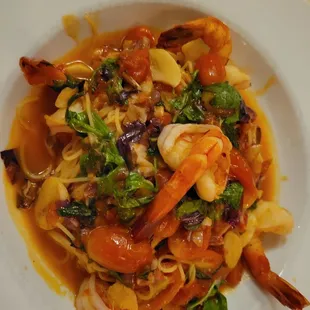 a plate of pasta with shrimp and vegetables