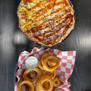 a plate of onion rings and a pizza