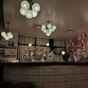 a bar with a lot of lights hanging from the ceiling